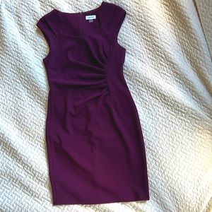 Gorgeous plum color dress with slimming waist and uniquely cut neckline.